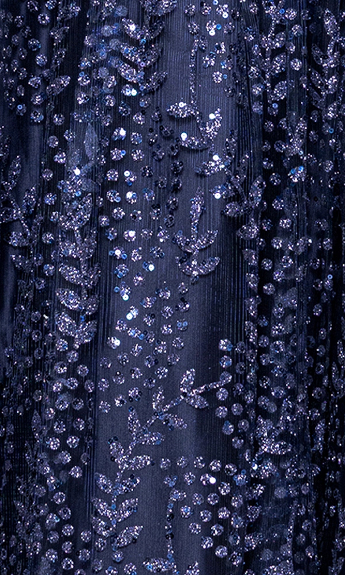 Close-up of the Glitter-Print Prom Ball Gown: Blondie Nites 5539BN, featuring dark blue fabric embellished with shimmering sequins and intricate leaf and dotted patterns.